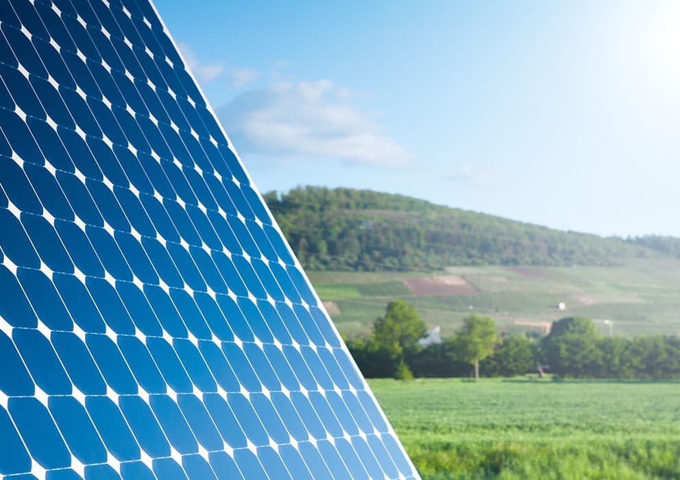 Photovoltaikmodul vor sonniger Landschaft